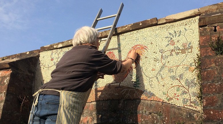 Helen Miles replacing missing tiles in the garden mosaic at Kirkennan