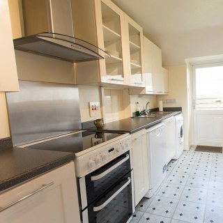 The kitchen offers an electric cooker, microwave, dishwasher and washing machine